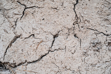 Old cracked wall made of orange clay and straw.