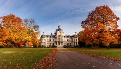 Obraz premium large ornate mansion domed roof set countryside surrounded trees adorned autumn foliage