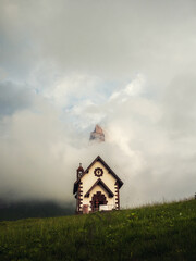 Vertical photo of a little alpine church in the dolomites region 