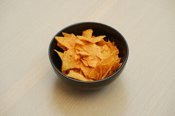 Nachos chips in a bowl on a wooden table