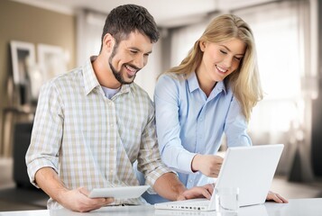 Fototapeta premium Happy young couple with laptop for finance planning