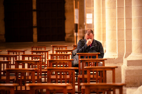 Lonely Man Sitting in an Empty Church Pew Reflecting in a Historic Church Interior