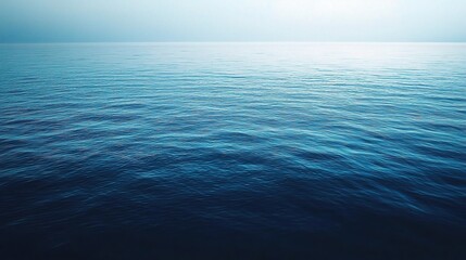 Obraz premium Deep Blue Serenity: A tranquil expanse of deep blue ocean stretches towards the horizon, the setting sun casting a soft glow on the rippling water. 