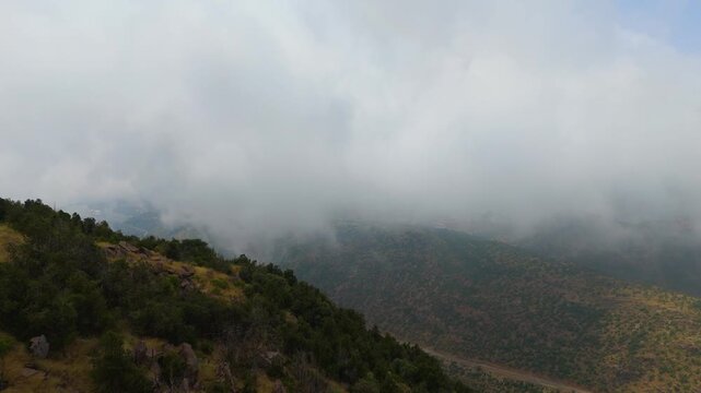 Stunning 4K drone footage of the Sarawat Mountains in Baha, Saudi Arabia. Capture the dramatic contrast of verdant peaks against a backdrop of swirling clouds. Ideal for travel, nature, and cinematic 