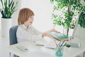 Photo of charming clever boy learner sitting chair table studying from home using modern technology indoors