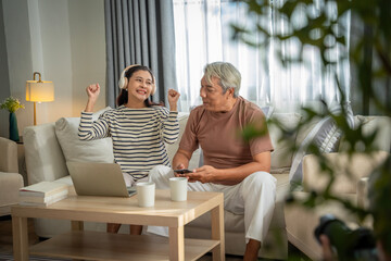 A man and woman are sitting on a couch, both wearing headphones