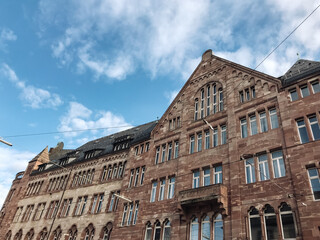 A large brick building with a blue sky in the background. The building has a lot of windows and a tall roof