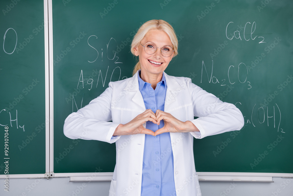 Sticker Photo of happy senior woman college teacher wear white coat isolated on green board background