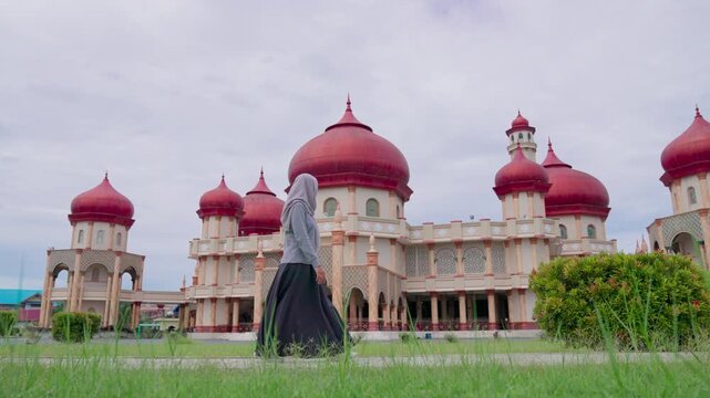Woman is walking towards the Great Mosque of Baitul Makmur in Indonesia