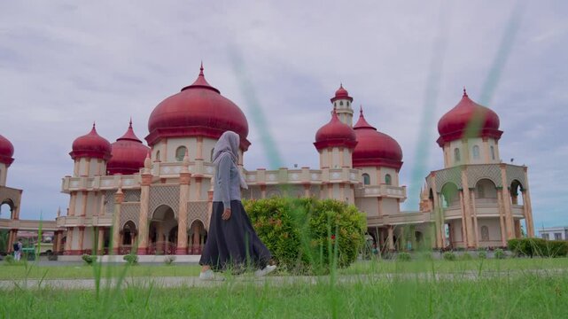 Woman is walking towards the Great Mosque of Baitul Makmur in Indonesia