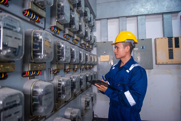Electrical maintenance engineer is checking .Electricity meter, main distribution board and write...