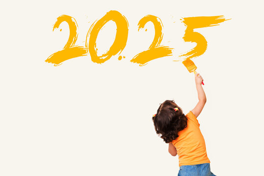 Cute little girl drawing new year 2025 with painting brush on wall background