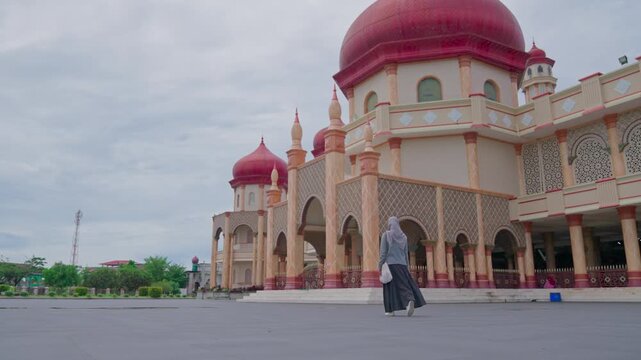 Woman is walking towards the Great Mosque of Baitul Makmur in Indonesia