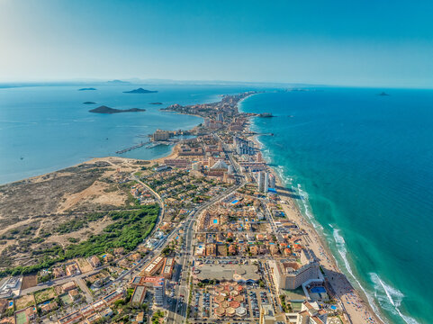 Aerial view of La Manga seaside spit of Mar Menor in the Region of Murcia, Spain, long strip full of hotels, vacation homes popular for local tourists