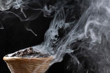 Roasted Coffee Beans in Small Basket. White Smokes on Black Background