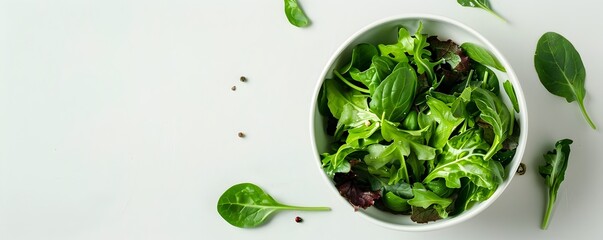 Obraz premium Clean Bowl of Organic Mixed Greens on White Background with Ample Copy Space