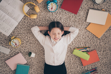 Photo portrait of small cute daughter lying floor hands behind head done remote education home schooling isolated indoors background