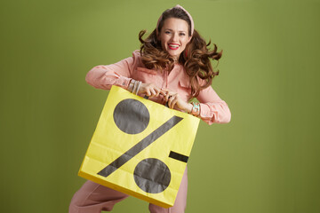 happy trendy female in pink blouse against green background