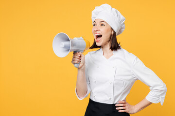 Young fun chef cook baker woman wear white shirt black apron uniform toque chefs hat hold megaphone...