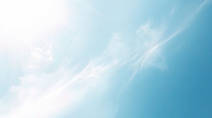 Azure Canvas: Wispy white clouds dance across a vibrant blue sky, kissed by the radiant glow of the sun. 
