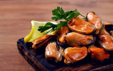 mussels without shell, boiled, mussels, peeled, on a chopping board, with lemon and parsley, mussels in Chilean, top view, no people,