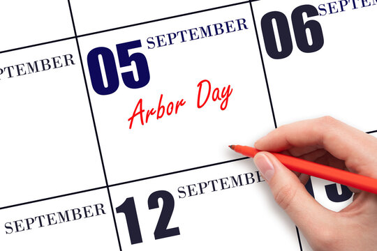 September 5. Hand writing text Arbor Day on calendar date. Save the date.
