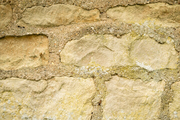 Close-up of Weathered Stone Wall Showing Textured Surface and Natural Patterns