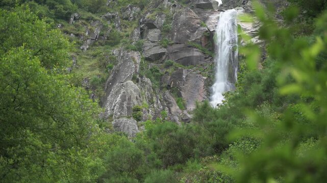tall waterfall in the mountains and forest. Frecha da Mizarela, Portugal.