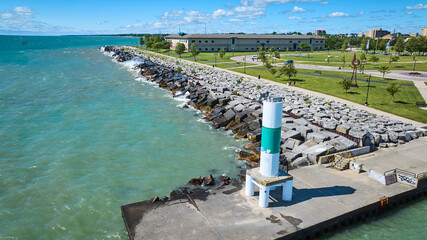 Aerial Fly Through of Green and White Lighthouse on Pier at Lake Michigan