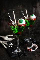 Halloween green martini  drink in  glass on dark  background