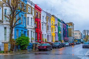 Rainy day in the Notting Hill neighborhood, on Lancaster Road, the legendary street of colorful Victorian-style houses with the reflection of the houses on the sidewalk and wet street.