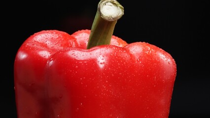 Macrography of a red bell pepper against a sleek black background takes center stage. Each close-up...
