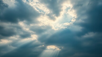 Fototapeta premium A dramatic sky with clouds and rays of sunlight breaking through.