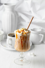 Iced caramel latte topped with whipped cream and caramel sauce.