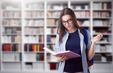 Happy young student in library with books