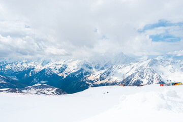 A picturesque view of the rocky white peaks of the mountains of the North Caucasus range from the snow-covered slope of Mount Elbrus. Caucasus