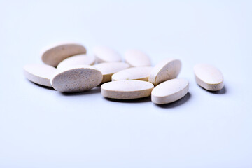 Ashwagandha (Withania somnifera) tablets. Concept for a healthy dietary supplementation. Bright paper background. Close up. Copy space.