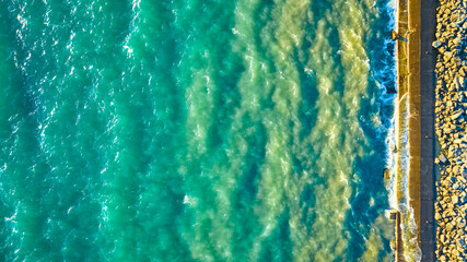 Aerial View of Turquoise Waves Crashing Against Wisconsin Pier