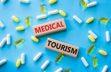 Medical Tourism symbol. Concept word Medical Tourism on wooden blocks. Beautiful blue background with pills. Medicine and Medical Tourism concept. Copy space