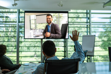 Video Conference call. Man CEO on big screen answering questions to his colleagues.