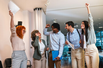 Portrait of multiracial business people. Celebrating their success. Throwing papers and smiling.