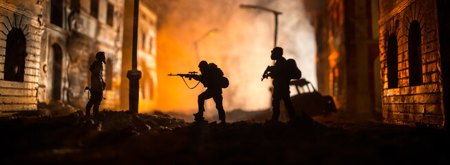 War Concept. Battle scene on war fog sky background, Fighting silhouettes Below Cloudy Skyline at night. City destroyed by war