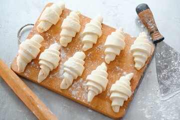Close up on raw croissants before baking. Classic French pastry made of Viennoiserie dough with vanilla creme