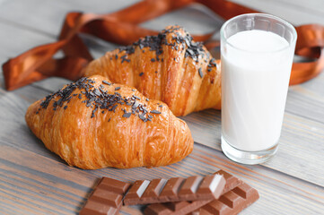 several milk chocolate and chocolate croissants with a glass of milk