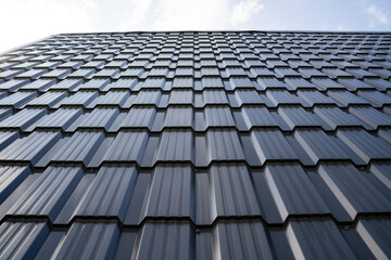 The facade of a modern building featuring uniquely designed, textured panels that enhance its aesthetic appeal