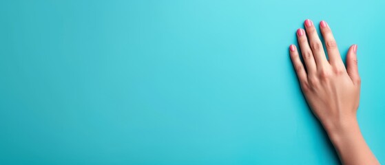  Woman's hand against blue backdrop Nails painted pink