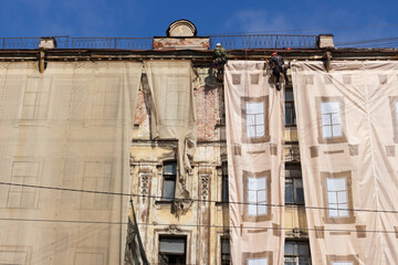 Repair work of the facade of an old building at an altitude