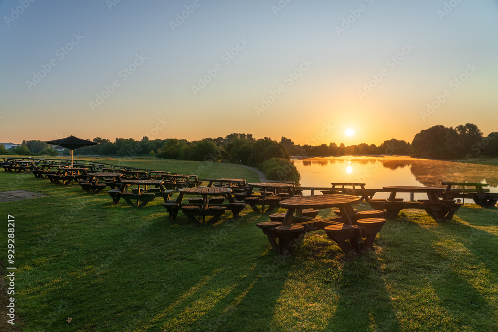 Sticker Wooden empty tables near lake at sunrise. Caldecotte lake. Milton Keynes. England