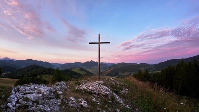Christian cross on a rock in a mountain landscape, Dramatic clouds over the mountains