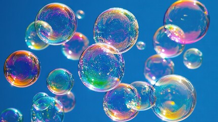 Naklejka premium Soap bubbles float in the blue sky, their colors multiplied
